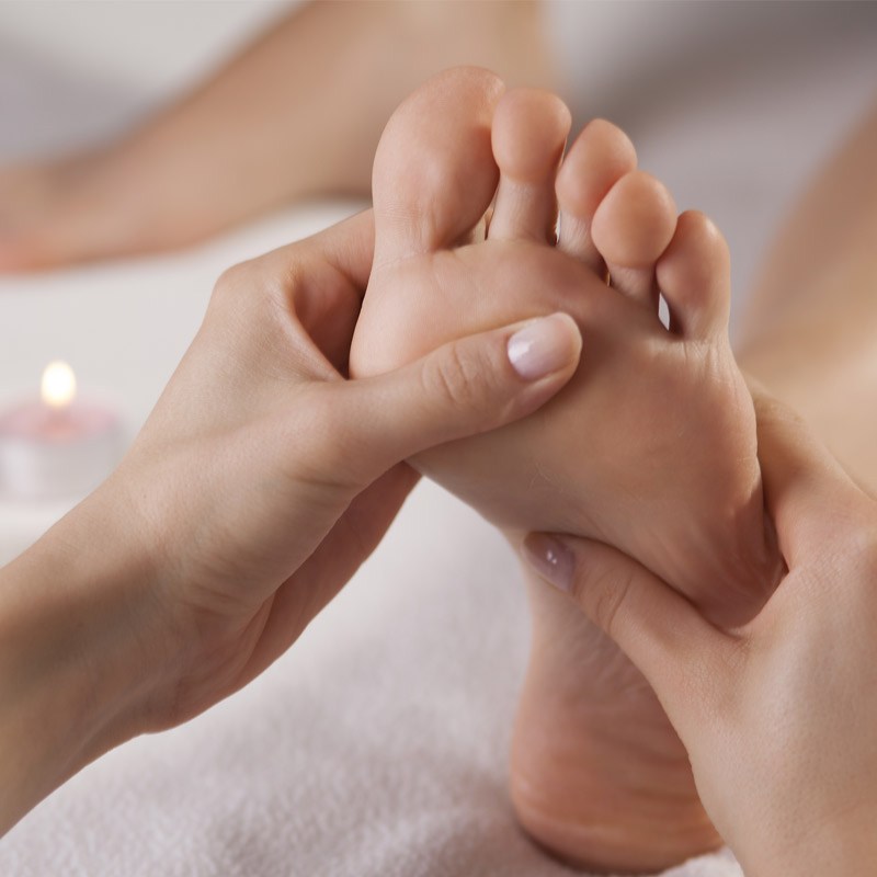 Sanfte Fussreflexzonenmassage: Hände behandeln gezielt eine Fusssohle